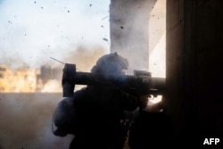 Seorang tentara Israel menembakkan senjata di lokasi yang tidak ditentukan di Jalur Gaza di tengah pertempuran yang sedang berlangsung antara Israel dan kelompok militan Palestina Hamas. (Foto: AFP)