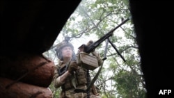 Seorang tentara Ukraina dari Brigade Mekanik Terpisah ke-28 menembak ke arah posisi Rusia di garis depan dekat kota Bakhmut, wilayah Donetsk, pada 17 Juni 2023, di tengah invasi Rusia ke Ukraina. (Foto: AFP)