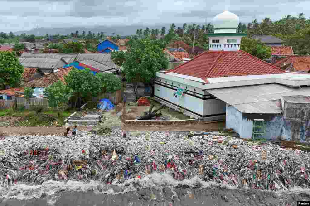 A drone view shows trash being swept to the shore due to high tides caused by erratic weather, on a beach in Teluk fishing village, in Pandeglang regency, Banten province, Indonesia, March 15, 2024. 
