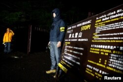 สมาชิกสำนักงานจังหวัดยามานาชิ ยืนประกอบประตูทางขึ้นภูเขาไฟฟูจิที่เพิ่งถูกติดตั้งเมื่อไม่นานมานี้ เพื่อคัดกรองนักท่องเที่ยวที่ชำระค่าธรรมเนียมปีนเขา ภายใต้แผนจำกัดนักปีนเขาซึ่งเริ่มต้นในวันที่ 1 ก.ค 2567