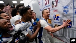 Pittsburgh guard Ishmael Leggett, right, places a decal on the bracket after an NCAA college basketball game on March 14, 2024. (AP Photo/Susan Walsh, File)