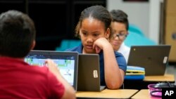 FILE - Aaliyah Ibarra and fellow students work on their computers during the last week of classes at Frye Elementary School in Chandler, Ariz., Tuesday, May 23, 2023. (AP Photo/Darryl Webb)
