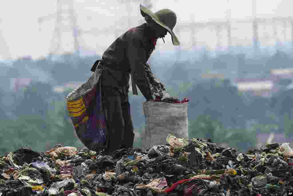 Seorang pemulung mencari barang-barang yang dapat didaur ulang di tumpukan sampah di tempat pembuangan sampah di Depok di pinggiran Jakarta, Indonesia.