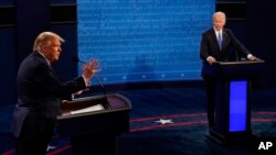 FILE - Then-President Donald Trump answers a question as Democratic presidential candidate Joe Biden listens during the second and final presidential debate, Oct. 22, 2020, at Belmont University in Nashville, Tennessee.