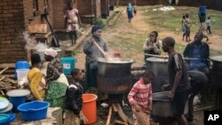 FILE - Community volunteers prepare meals for people who were displaced following heavy rains by tropical Cyclone Freddy at Manja displacement center in Blantyre, southern Malawi, March 16, 2023.