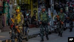 Indian paramilitary soldiers patrol a busy market in Srinagar, Indian controlled Kashmir, Aug 1, 2023. 