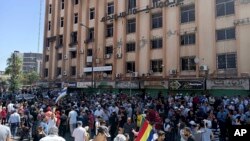 In this photo released by Suwayda24, people stage a protest in the southern city of Sweida, Syria, Aug 22, 2023. 