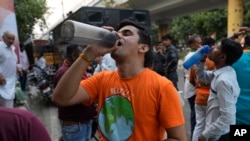 FILE - Seorang pria minum air di sebuah warung pinggir jalan yang menyajikan air minum gratis kepada para penumpang, ketika gelombang panas terus melanda ibu kota India, New Delhi, 22 Mei 2024. (AP/Manish Swarup)