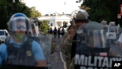 FILE - In this June 1, 2020, file photo police clear the area around Lafayette Park and the White House in Washington, as demonstrators gather to protest the death of George Floyd.