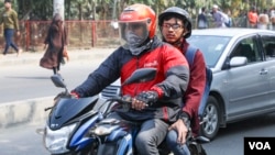 A biker takes a customer on pillion as part of ridesharing service in Dhaka. (Kazi Salahuddin Razu/VOA)