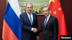 왕이 중국 외교부장(오른쪽)과 세르게이 라브로프 러시아 외무장관(왼쪽)이 20일 카자흐스탄에서 만난 악수하고 있다.