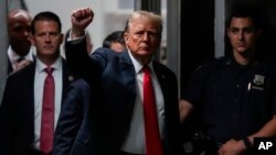 도널드 트럼프 전 미국 대통령이 28일 뉴욕 맨해튼형사법원에서 열린 재판에 출석하면서 취재진을 향해 주먹을 들어 보이고 있다. 