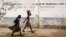 FILE - Girls walk on a road in Maroua, Cameroon, March 17, 2016. Cameroon’s government says 70% of menstruating women and girls lack access to regular basic sanitation products. 