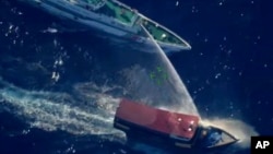 Kapal pasokan Filipina Unaizah 4 Mei, kanan, terkena semprotan air Garda Pantai China yang menyebabkan beberapa awak kapal terluka saat mereka mencoba memasuki Second Thomas Shoal, di Laut China Selatan, 5 Maret 2024. (Foto: via AP )