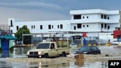 Magari yanapita kwenye mafuriko yaliyosababishwa na mvua kubwa iliyonyesha katika mji mkuu wa Libya, Tripoli. Oktoba 19, 2022. Picha na Mahmud TURKIA / AFP. 