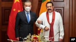 资料照片: 2022年1月9日中国外交部长王毅(左)在斯里兰卡科伦坡会见时任斯里兰卡总理马欣达·拉贾帕克萨