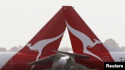 FILE: Dua jet penumpang Qantas saling bersilangan di bandara Internasional Kingsford Smith di Sydney, 27 Juni 2013. (REUTERS/Daniel Munoz)