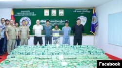 មន្ត្រី​ប្រចាំ​មន្ទីរប្រឆាំងបទល្មើសគ្រឿងញៀន​បង្ហាញ​គ្រឿងញៀន​ដែល​រឹបអូសបាន​និង​ឧក្រិដ្ឋជន​ចំនួន​ ៥នាក់ នៅ​មន្ទីរប្រឆាំងបទល្មើសគ្រឿងញៀន រាជធានីភ្នំពេញ កាលពីថ្ងៃទី២៤ ខែមករា ឆ្នាំ២០២៤។ (Facebook/Anti-Drug Department)