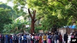 Travelers are seen in a queue outside the passport offices in Harare, Zimbabwe, Dec. 20, 2023.