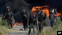 Police officers throw stones towards supporters of Pakistan's former Prime Minister Imran Khan during clashes, in Islamabad, Pakistan, May 10, 2023.