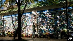 Žena dodiruje fotografiju ukrajinskog vojnika na spomeniku ukrajinskim vojnicima poginulim tokom rata, u katedrali Svetog Mihaila u Kijevu, Ukrajina, 8. maja 2024.