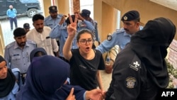 Petugas polisi menghadirkan pengacara dan aktivis hak asasi manusia yang ditangkap, Imaan Mazari-Hazir (tengah) di hadapan pengadilan di Islamabad pada 20 Agustus 2023. (Foto: AFP)