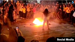 تصویری از اعتراضات سراسری ۱۴۰۱، آتش زدن روسری توسط یک معترض جوان ـ آرشیو