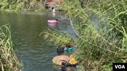 从墨西哥边境城市渡河前往对岸美国德州边境城市布朗斯维尔的移民，其中包括中国人。