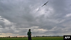 An operator controls a reusable airstrike drone called Punisher made by the Ukrainian company UA Dynamics during a test in Kyiv region on Aug. 11, 2023, amid Russian invasion in Ukraine.