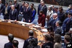After Ukraine Foreign Minister Dmytro Kuleba led a moment of silence for victims of war in his country, the U.N. Security Council stands for a second tribute at the insistence of Russian envoy Vassily Nebenzia, Feb. 24, 2023, at U.N. headquarters.