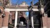 FILE - A passer-by walks through a gate to the Harvard University campus, in Cambridge, Massachusetts, Jan. 2, 2024. 