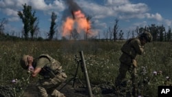 Ukrainian soldiers fire a mortar toward Russian positions at the front line, near Bakhmut, Donetsk region, Ukraine, Aug. 12, 2023.