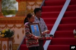 សាច់ញាតិ​កាន់​រូបថត​របស់​យោធិន​ម្នាក់​ដែល​បាន​ស្លាប់​ក្នុង​អំឡុង​ហេតុការណ៍​ផ្ទះ​គ្រាប់​មួយ​នៅ​ទី​បញ្ជាការ​ដ្ឋាន​យោធ​ភូមិភាគ​ទី៣ ក្នុង​ខេត្ត​កំពង់​ស្ពឺ​ ដែល​បណ្តាល​ឱ្យ​យោធិន​២០​នាក់​ស្លាប់​បាត់​បង់​ជីវិត ថ្ងៃទី ២៨ ខែមេសា ឆ្នាំ២០២៤។​ (AKP via AP)