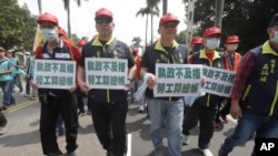 Taiwanese workers hold slogans reading "Failure to govern and workers will come settle the score" during a May Day rally in Taipei, Taiwan, May 1, 2023.