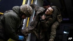우크라이나군 장병들이 지난 26일 바흐무트 인근 야전병원으로 부상병을 후송하고 있다.