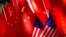 FILE - The flags of China and the U.S. are displayed on top of a trishaw in Beijing, Sept. 16, 2018. 