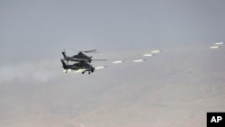 Dua helikopter tempur militer China menembakkan roket selama latihan perang bersama militer Rusia dan China di China barat laut, 13 Agustus 2021 (foto: dok). 