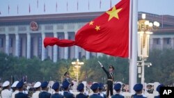 Китайский почетный караул разворачивает национальный флаг Китая на церемонии, посвященной 73-й годовщине основания Китайской Народной Республики, Пекин, 1 октября 2022 года.