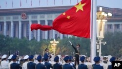 FILE - A Chinese honor guard unfurls the Chinese national flag in Beijing, Oct. 1, 2022. Several Western democracies are working to restart diplomatic engagement with China, while also defending their own countries' interests.