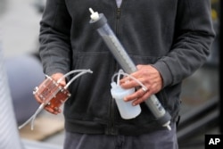 Dante Simonetti holds a small-scale model of technology called SeaChange on April 12, 2023, in San Pedro, Calif. (AP Photo/Ashley Landis)