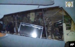 Dalam gambar yang diambil dari video dari RTN, pasukan militer Rusia menurunkan peralatan dari pesawat angkut militer di pangkalan udara Niamey di Niamey, Niger, 10 April 2024. (RTN via AP)