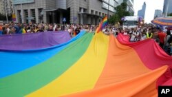 FILE - People carry a rainbow flag during the yearly Pride parade, known as the Equality Parade, in Warsaw, Poland, June 17, 2023. 