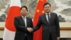 Menlu Jepang Yoshimasa Hayashi berjabat tangan dengan Menlu China Qin Gang di Beijing, China hari Minggu (2/4).