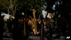 Israeli soldiers and family members visit the graves of fallen soldiers ahead of Israel's annual Memorial Day at Mount Herzl military cemetery in Jerusalem, May 9, 2024.