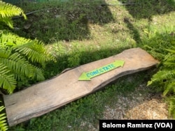 Pieces of wood were adapted in the solar forest as seats that at each end have connections to electricity. (Salome Ramirez/VOA)