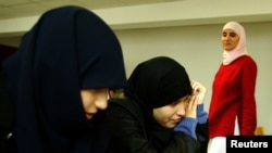 Karima Mokhtari (kanan) seorang guru bahasa Spanyol menyambut siswa pertama di bacaan "Averroes", sekolah menengah Islam swasta pertama yang dibuka di utara kota Lille, Paris 2 September 2003. (Foto: Reuters)