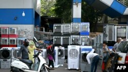 People buy air coolers from a roadside vendor on a hot summer afternoon in New Delhi on May 20, 2024, amid the ongoing heatwave.