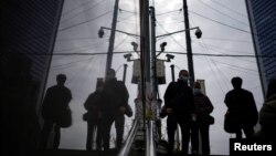 人们行走在装有监控摄像头的上海街头。（2022年12月12日）