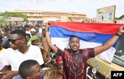 Pristalica Nacionalnog saveta Nigera za odbranu otadžbine maše zastavom Rusije (okrenutom naopako), tokom demonstracija u Nijameju, 6. avgsuta 2023. Hiljade pripadnika vojne hunte okupilo se na stadionu u Nimajemu u nedelju, kada je isticao rok zapadnoafričkog regionalnog bloka ECOWAS za vraćanje svrgnutog predsednika Mohameda Bazouma na vlast.