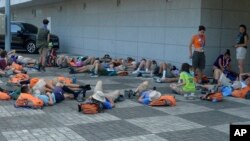 Attendees at the World Scout Jamboree lie down to rest at a camping site in Buan, South Korea, Aug. 4, 2023. 
